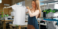Nice woman tailor holding just sewn t-shirt - Краевое профобъединение