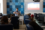 Преподаватель в учебном классе демонстрирует школьникам обжим сетевого кабеля, на экране — инструкция по изготовлению прямого кабеля по схемам 568А и 568В.